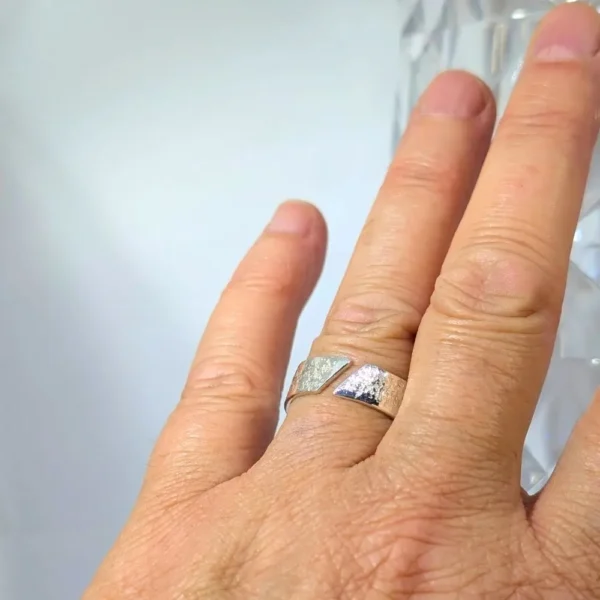 bague ouverte scintillante sur l'annulaire d'une main de femme