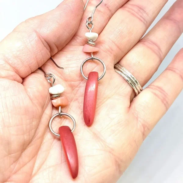 boucles d'oreilles en tagua et pierres posées sur une main