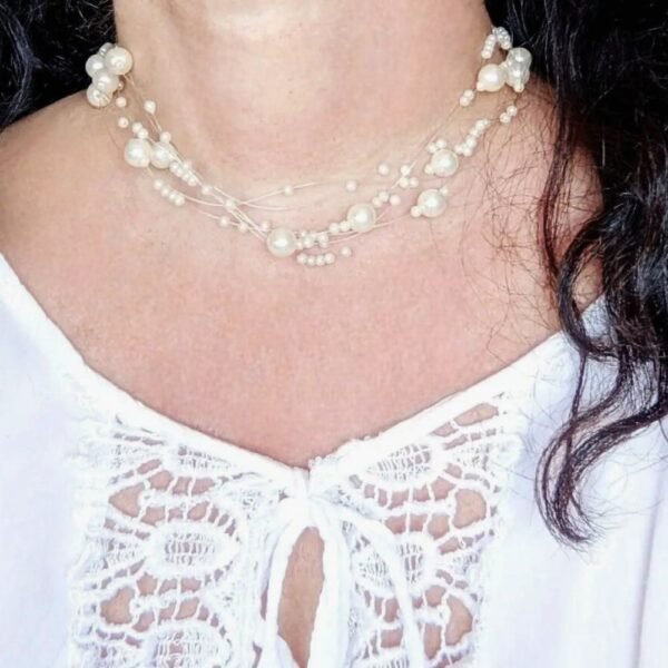 collier de perles blanches sur un buste de femme