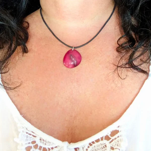 collier en tagua rose et cuir pendu au cou d'une femme brune