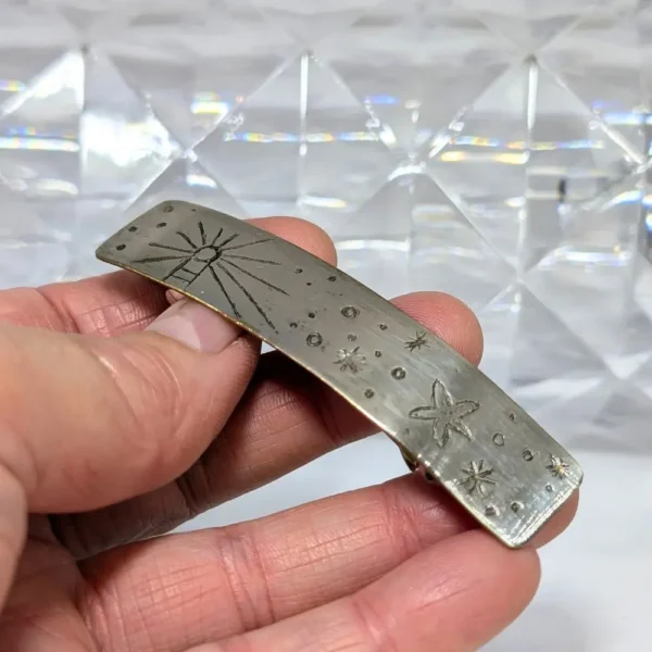 barrette argentée tenue dans une main