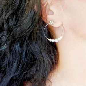 Promotions 64 créoles de perles blanches portées à l'oreille d'une femme